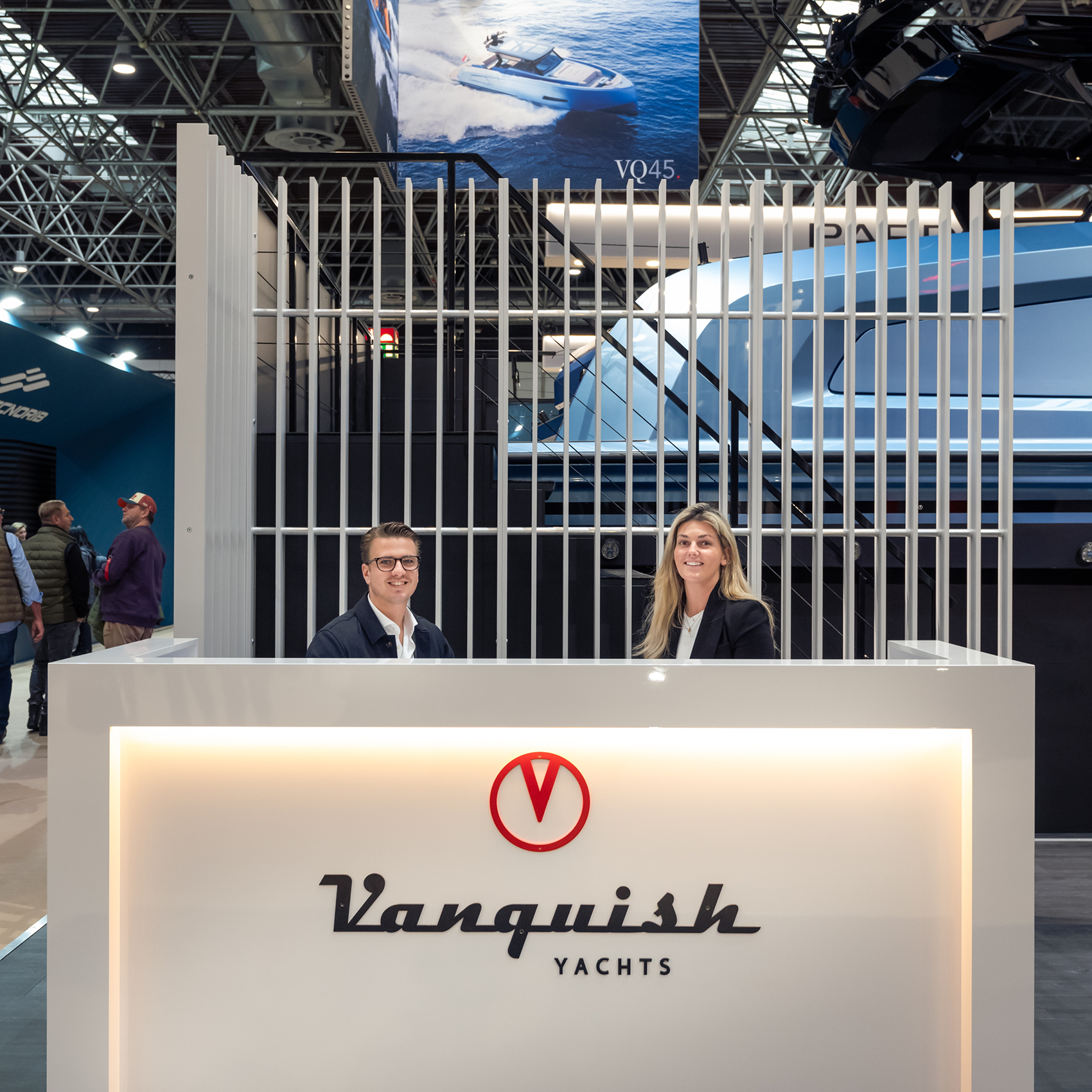 A Vanquish Yachts stand at a boat show with branded signing